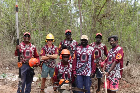 RAC workers stand in front of Coffee Bush weeds